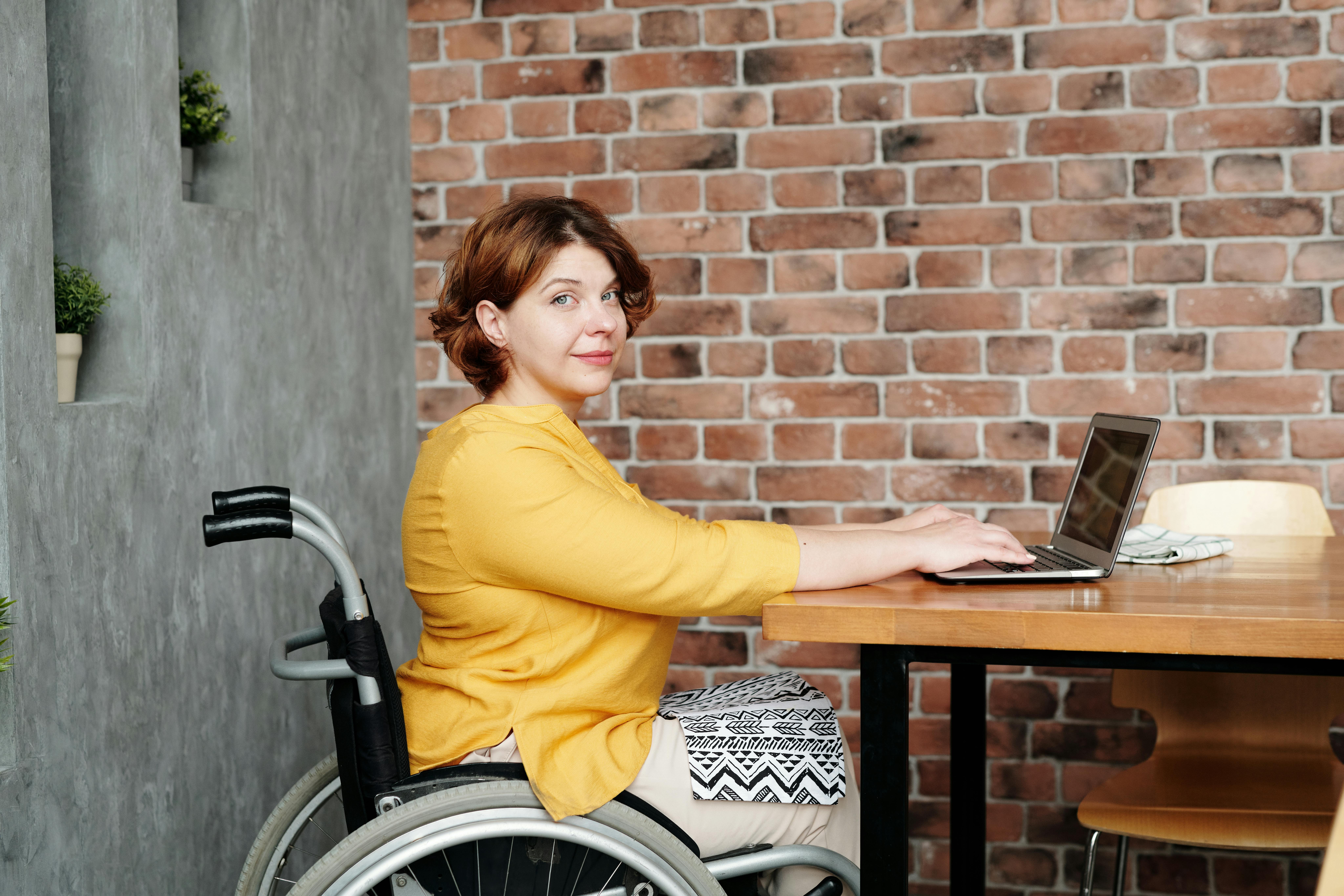 Mujer en silla de ruedas frente a una laptop
